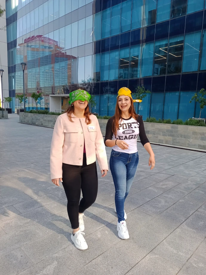 Foto de dos compañeras de trabajo realizando actividades integrales en las afueras de su edificio