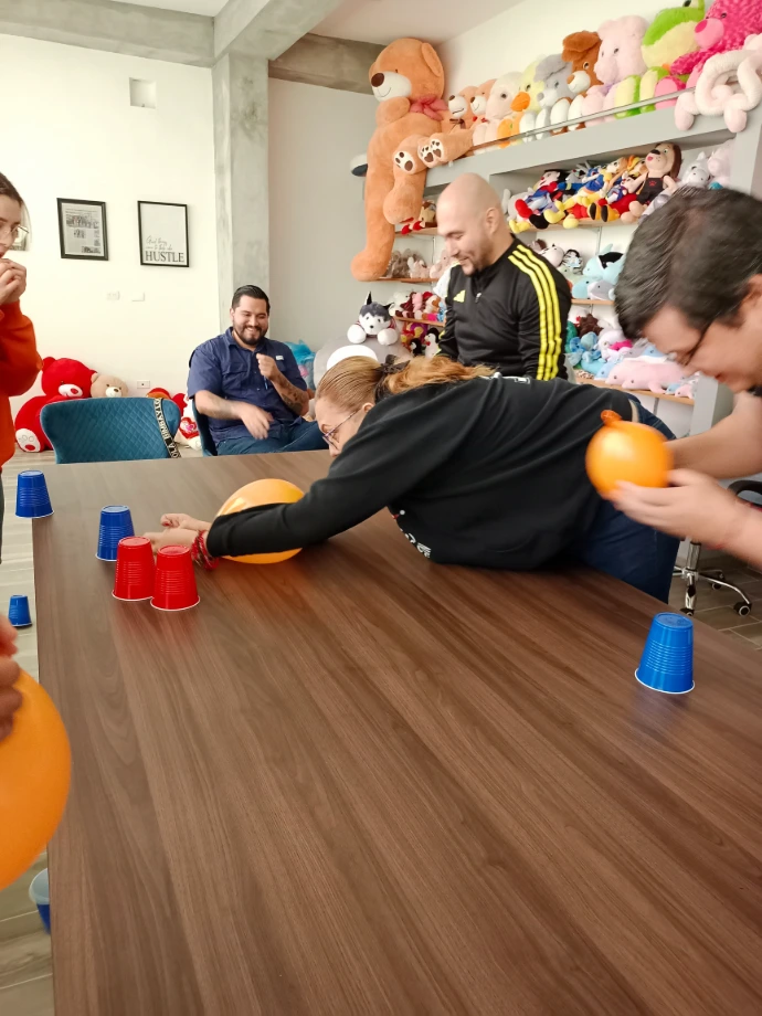 Fotografía de un equipo jugando en las actividades integrales de Econvalor realizadas con globos y vasos