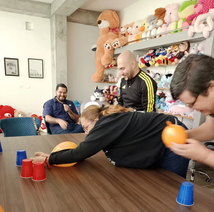 Fotografía de varios compañeros de trabajo jugando con globos a la par que hacen actividades de team building para empresas