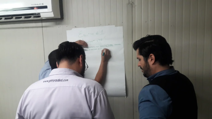 Foto de compañeros de oficina aprendiendo cuánto le cuesta a tu empresa NO capacitar a su equipo y sus costos ocultos