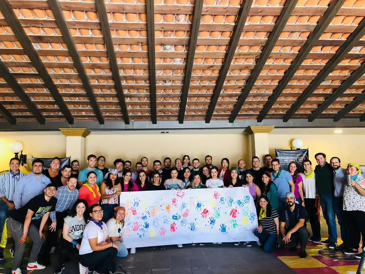 Grupo de integrantes de una empresa con un cartel que hicieron en una sesión de teambuilding Grupo de colaboradores sonrientes mostrando un cartel hecho durante una experiencia de team building Monterrey, diseñada para fortalecer la colaboración entre equipos.