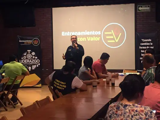 Conferencia impartida por un miembro de Econvalor para ayudar a un equipo de trabajo mediante un curso de ventas Hombre de parte del equipo de Econvalor dando inicio a una conferencia para un grupo de personas que solicitaron un curso de ventas