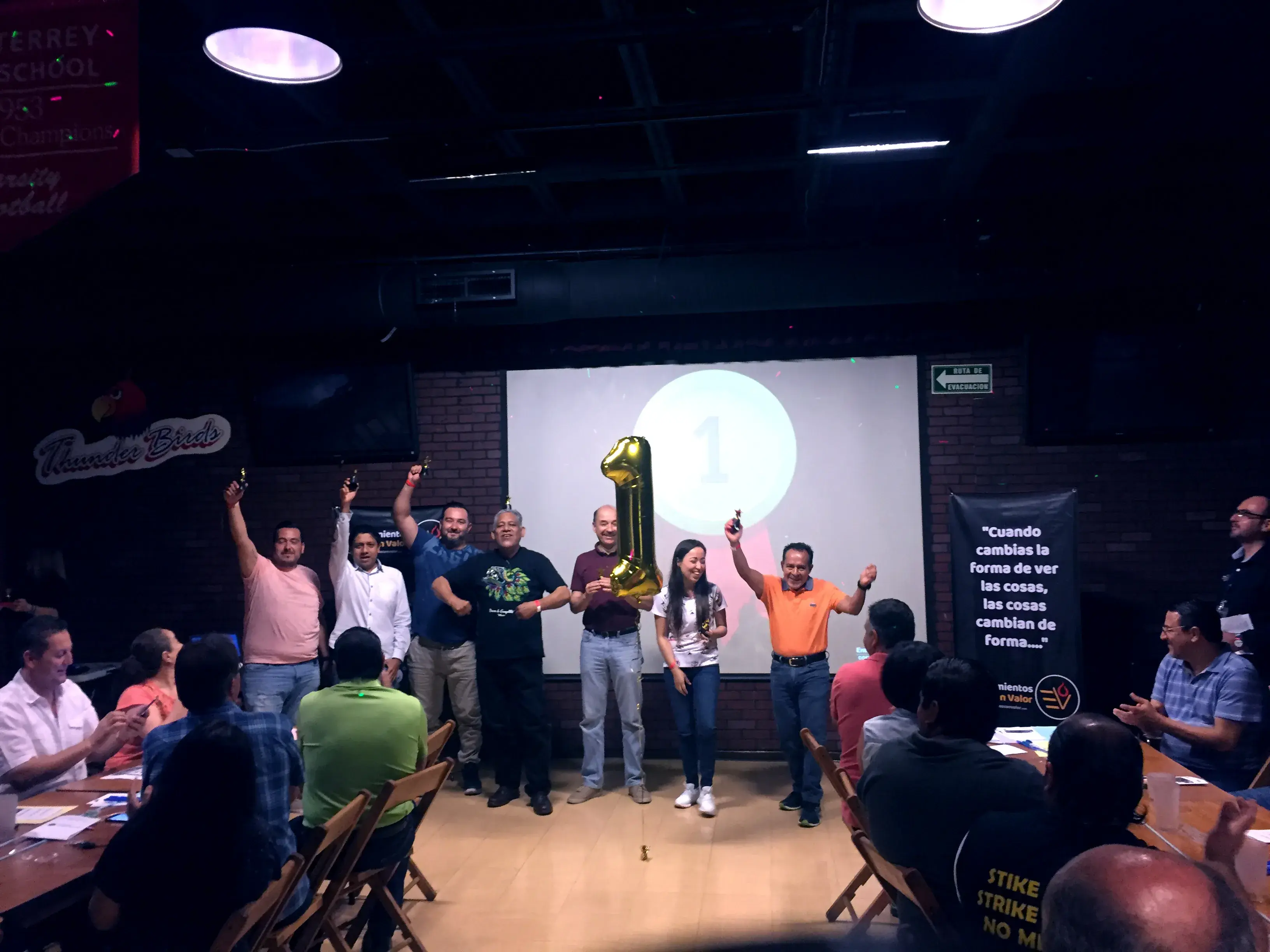 Equipo de Econvalor levantando la mano en símbolo de ser los No. 1 en brindar estrategias de psicología para éxito duradero en empresas y negocios