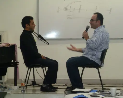 Foto de dos hombres sentados de frente conversando sobre la autoconciencia para liderar y vender.