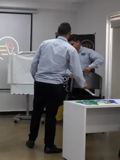 Compañeros de trabajo charlando sobre las diferencia entre jefe y líder Foto de Compañeros de trabajo charlando sobre las diferencia entre jefe y líder mientras reparan una silla de la oficina