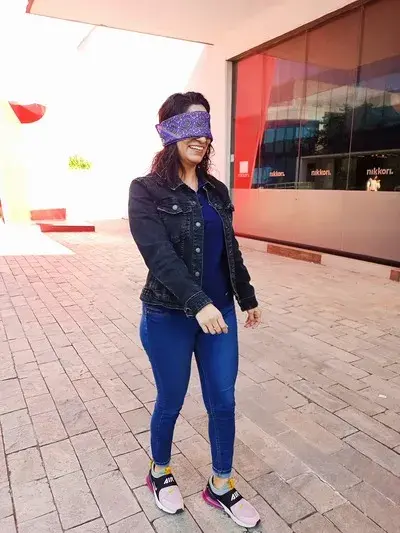Mujer disfrutando de las dinámicas para fortalecer el trabajo en equipo Foto de una Mujer con los ojos vendados disfrutando de las dinámicas para fortalecer el trabajo en equipo