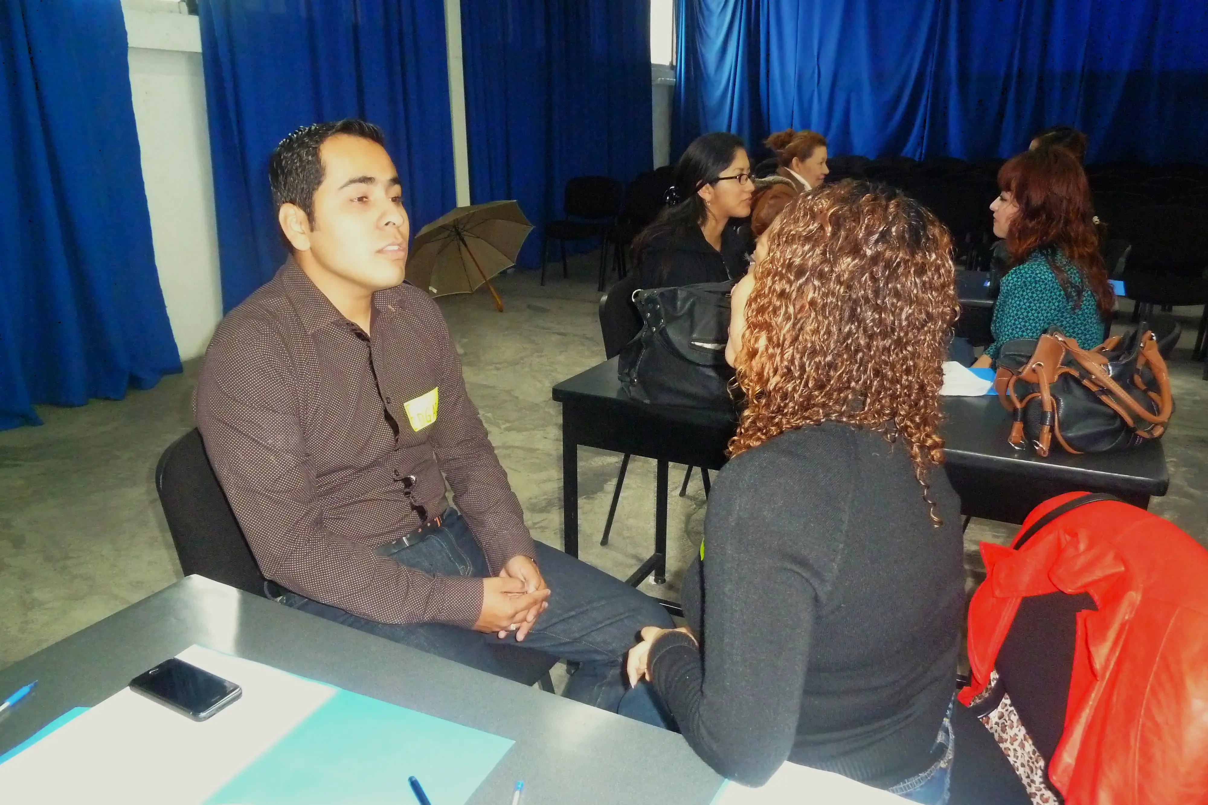 Fotografía de un Hombre y una mujer sentados frente a frente realizando una dinámica de comunicación empresarial